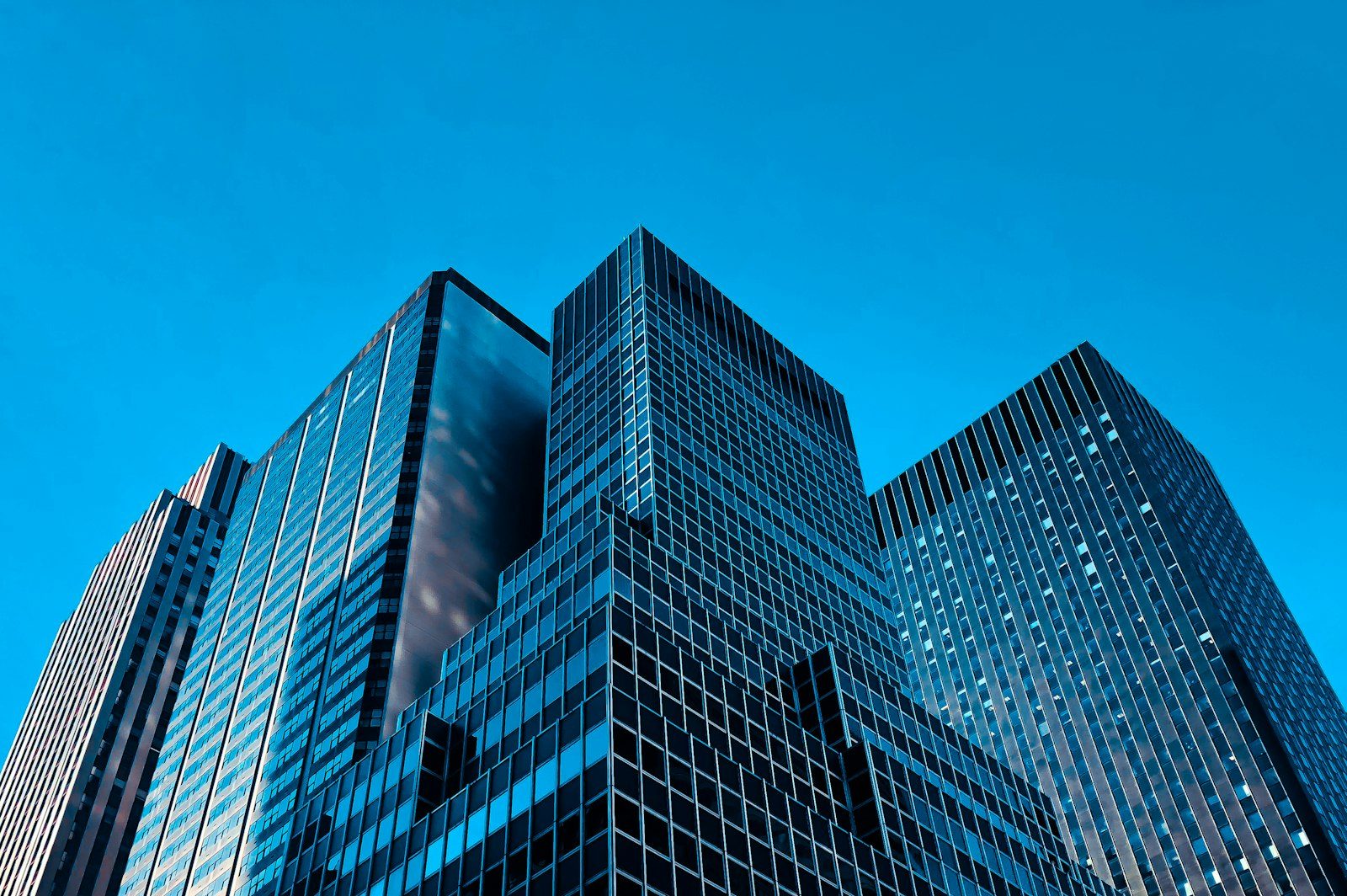 Glass office towers seen from street level against a clear sky