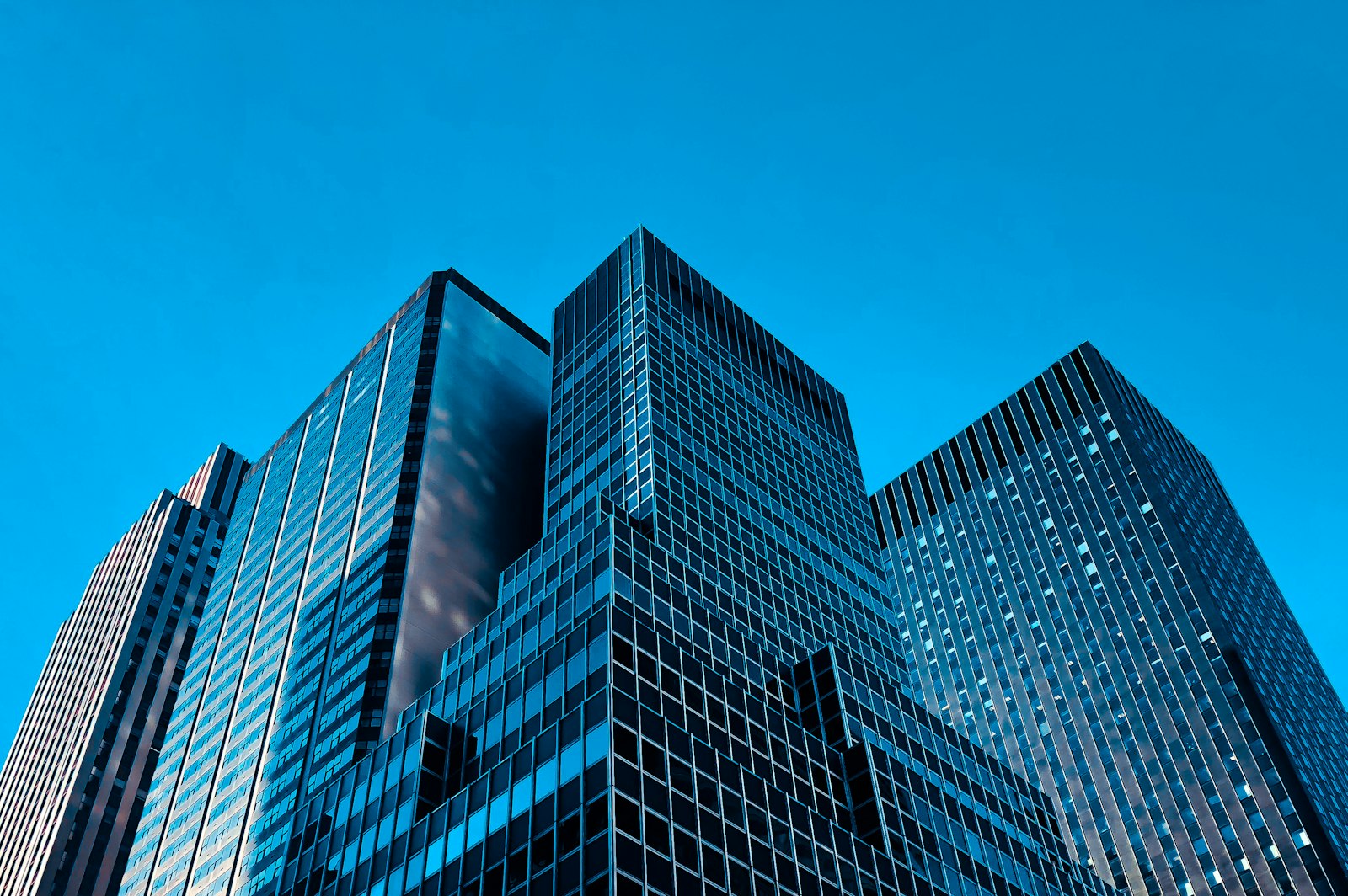 Glass office towers seen from street level against a clear sky